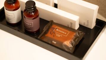 A tray with two bottles of Botanica conditioner, a bar of Botanica soap, and a white box.