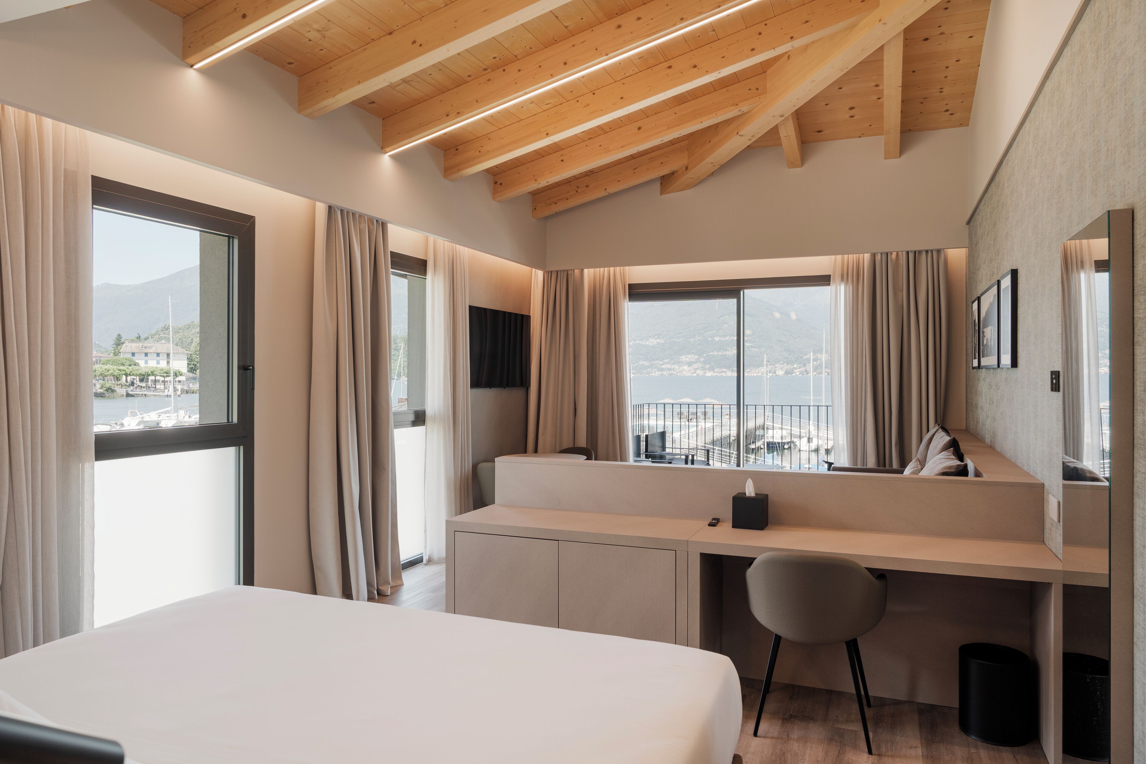 Habitación de hotel moderna con una cama grande, un escritorio y vista al mar.