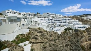 Un pueblo blanco en terrazas, con edificios sobre una colina.