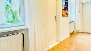 A hallway with a radiator, a door, and a painting on the wall. - Cozy Stay in Shared Apt  Short Walk to Westbahnhof (Vienna)