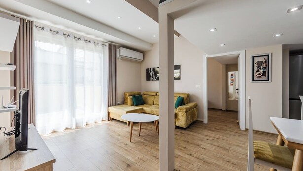 Una sala de estar moderna con sofá, mesa de centro y televisor.