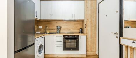 Een koelkast, een oven, een kookplaat, een koffiezetapparaat/waterkoker