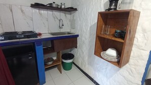 A compact kitchen with a gas stove, sink, and a small refrigerator. - Apartment in San Andres islands, with swimming pool, green areas and very quiet. (San Andrés y Providencia)