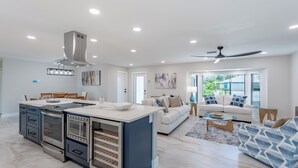 A spacious kitchen with a central island, built-in appliances, and a dining area with a table and chairs. - ☀️Private Pool | Canal Front with Boat Dock | Seas The Day☀️ (Fort Myers Beach)