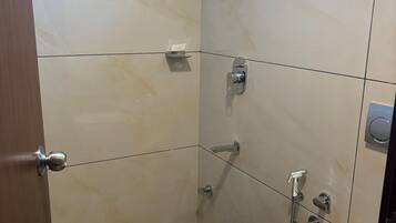 A small, modern bathroom with a toilet, bidet, and shower.