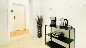 A modern kitchen with a coffee maker, kettle, and a decorative vase.