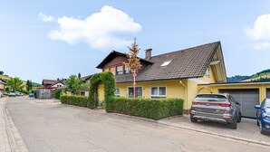 A residential street with houses, parked cars, and a clear sky. - Waldrose Apartment with Mountain View, Private Terrace, and Wi-Fi (Oberharmersbach)