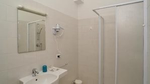 A bathroom with a sink, mirror, and shower. - AS VILLARTE (Agliana)