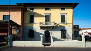 A two-story building with a balcony, a gate, and a sign for a bar and cafe. - AS VILLARTE (Agliana)