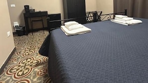 A hotel room with a large bed, a desk, a wardrobe, and a flat-screen TV on the wall. - AS VILLARTE (Agliana)