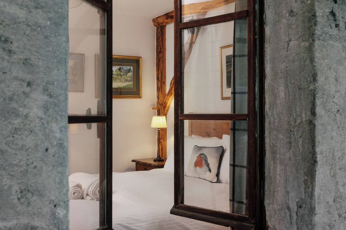 Una stanza con un letto, una lampada e un quadro appeso al muro.