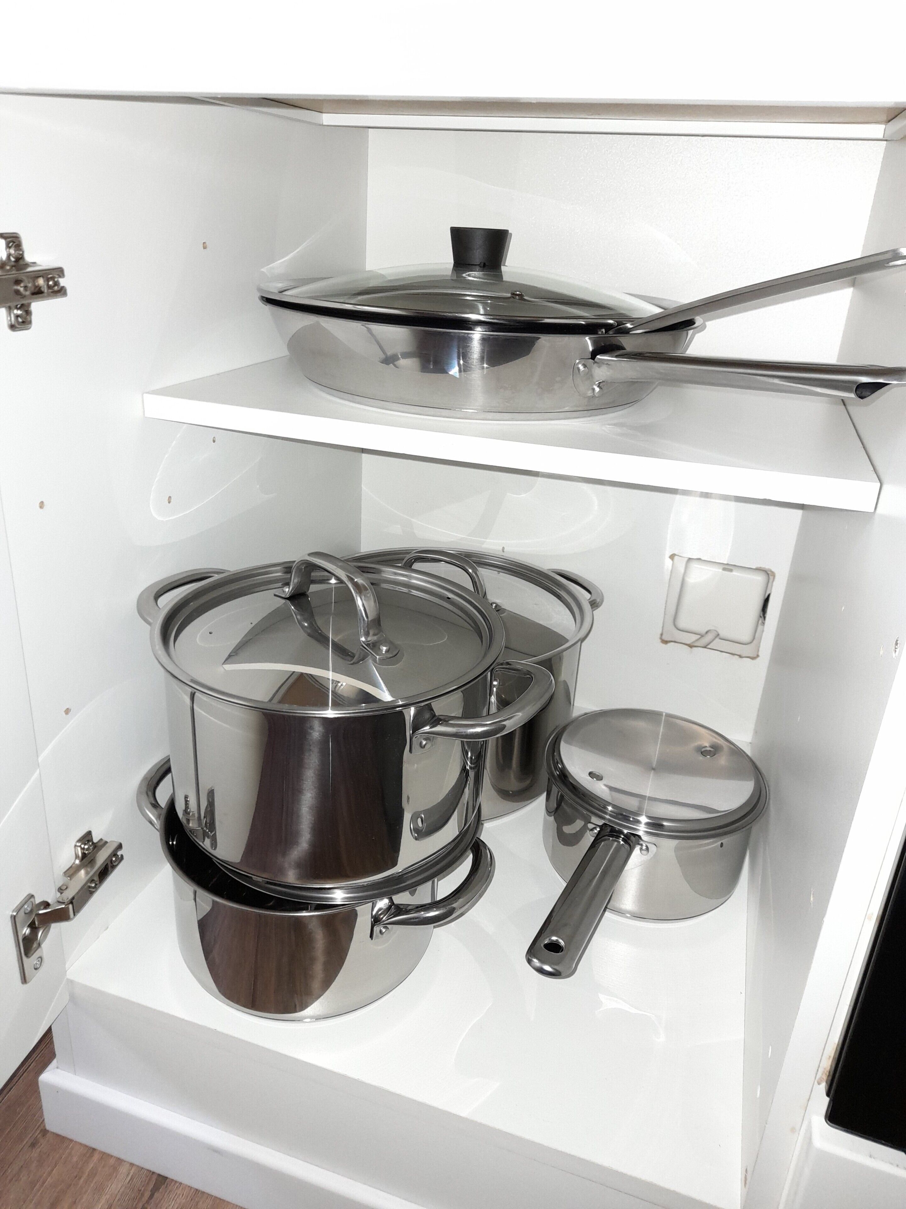 Una cocina con utensilios de acero inoxidable en estantes.