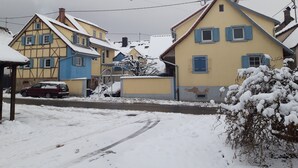 Une rue résidentielle bordée de maisons enneigées, sous un ciel dégagé.