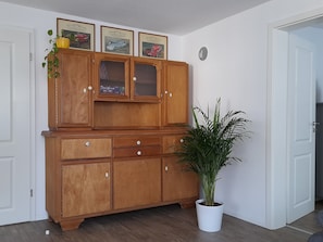 Eine Holzkabine mit mehreren Schubladen und einer Blumentopf-Pflanze daneben.