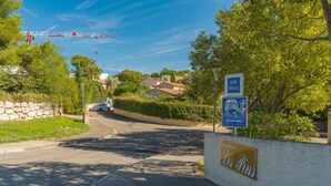 A street view with a sign for 'Les Pins' and a crane in the background. - Studio Apartment 'La Dolce Vita 2' with Shared Pool, Private Terrace and Air Conditioning (Lambesc)