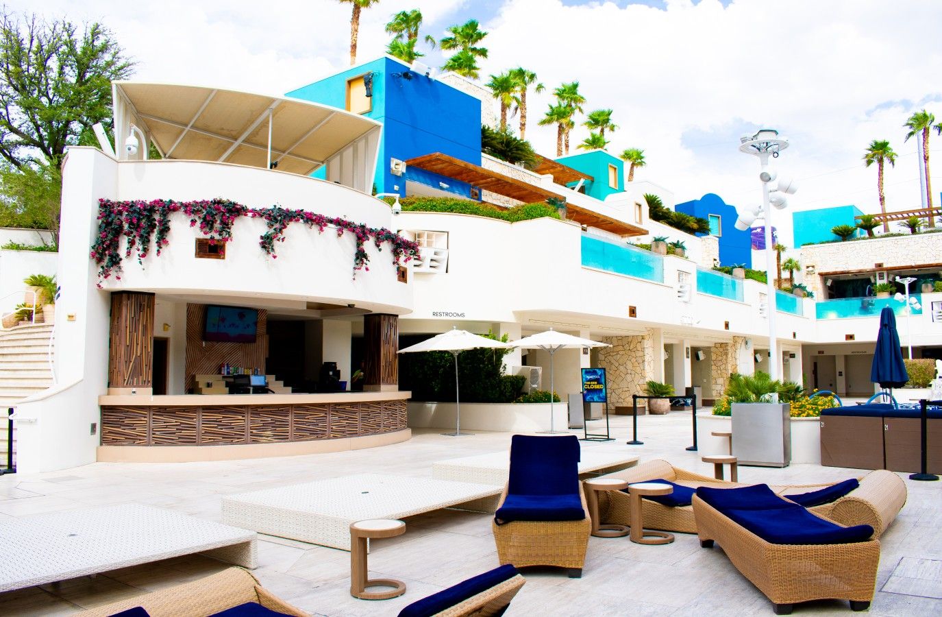 A hotel with a pool area, outdoor seating, and a restaurant.