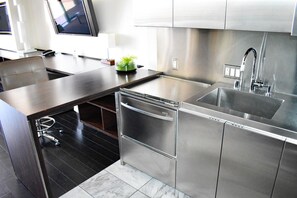 Une cuisine moderne équipée d’appareils électroménagers en acier inoxydable, d’un lave-vaisselle et d’un évier.