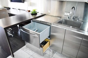 A modern kitchen with stainless steel appliances, a built-in dishwasher, and a sink.