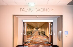 Un couloir intérieur mène au CASINO PALMS, et un panneau indiquant la SORTIE est placé au-dessus.