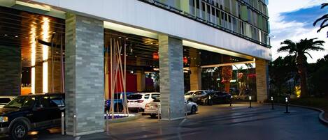 A hotel entrance with a modern design, featuring large pillars and a covered walkway.