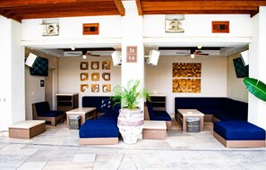 A modern lounge area with blue sofas, a central plant, and artwork on the walls. - Palms Place Hotel Mountain View with Open Balcony (Las Vegas)