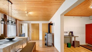 A modern kitchen with a built-in stove, wooden flooring, and a red cabinet. - Apartment 'Ferienwohnung Annette' with Shared Terrace and Wi-Fi (Gomadingen)
