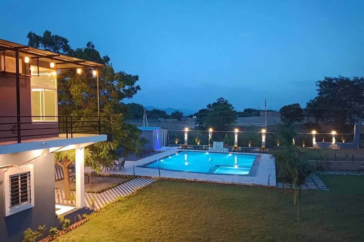 Une maison moderne dotée d’une piscine, d’un patio couvert et d’un espace extérieur bien éclairé.