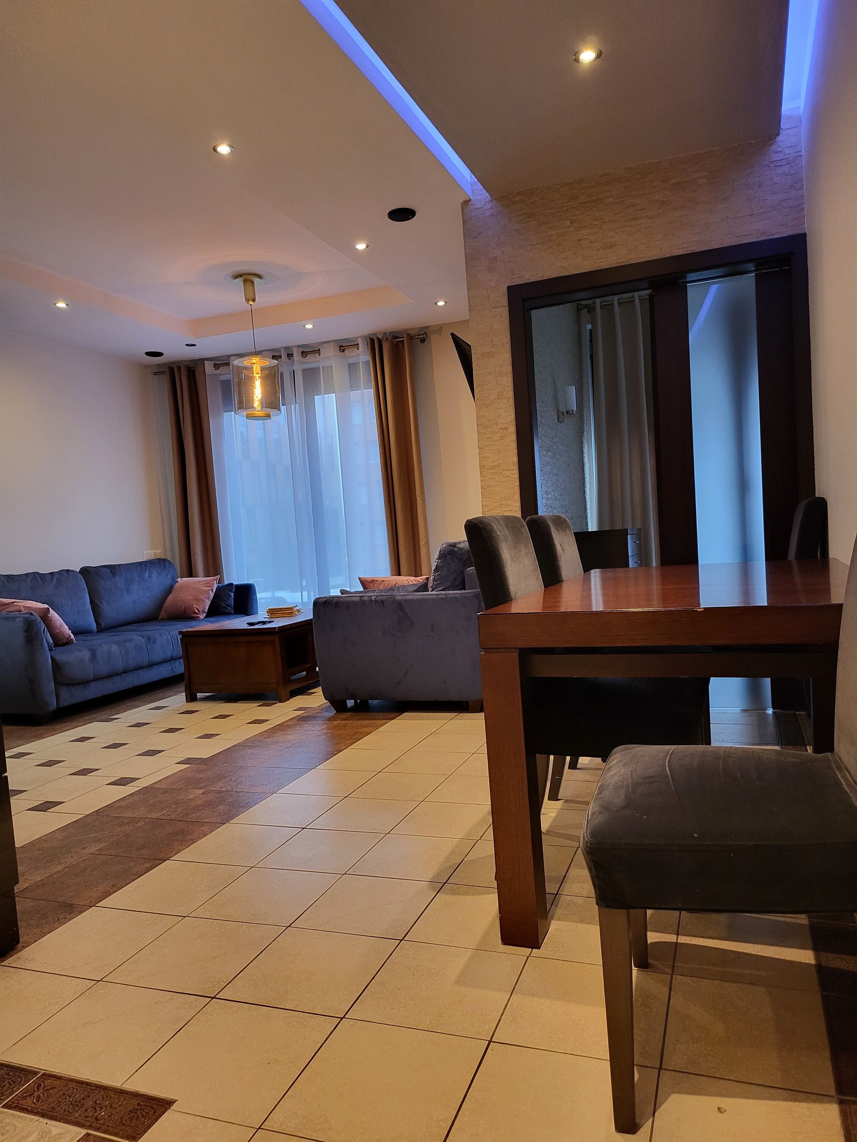 A modern living room with a sofa, a dining table, and a coffee table.
