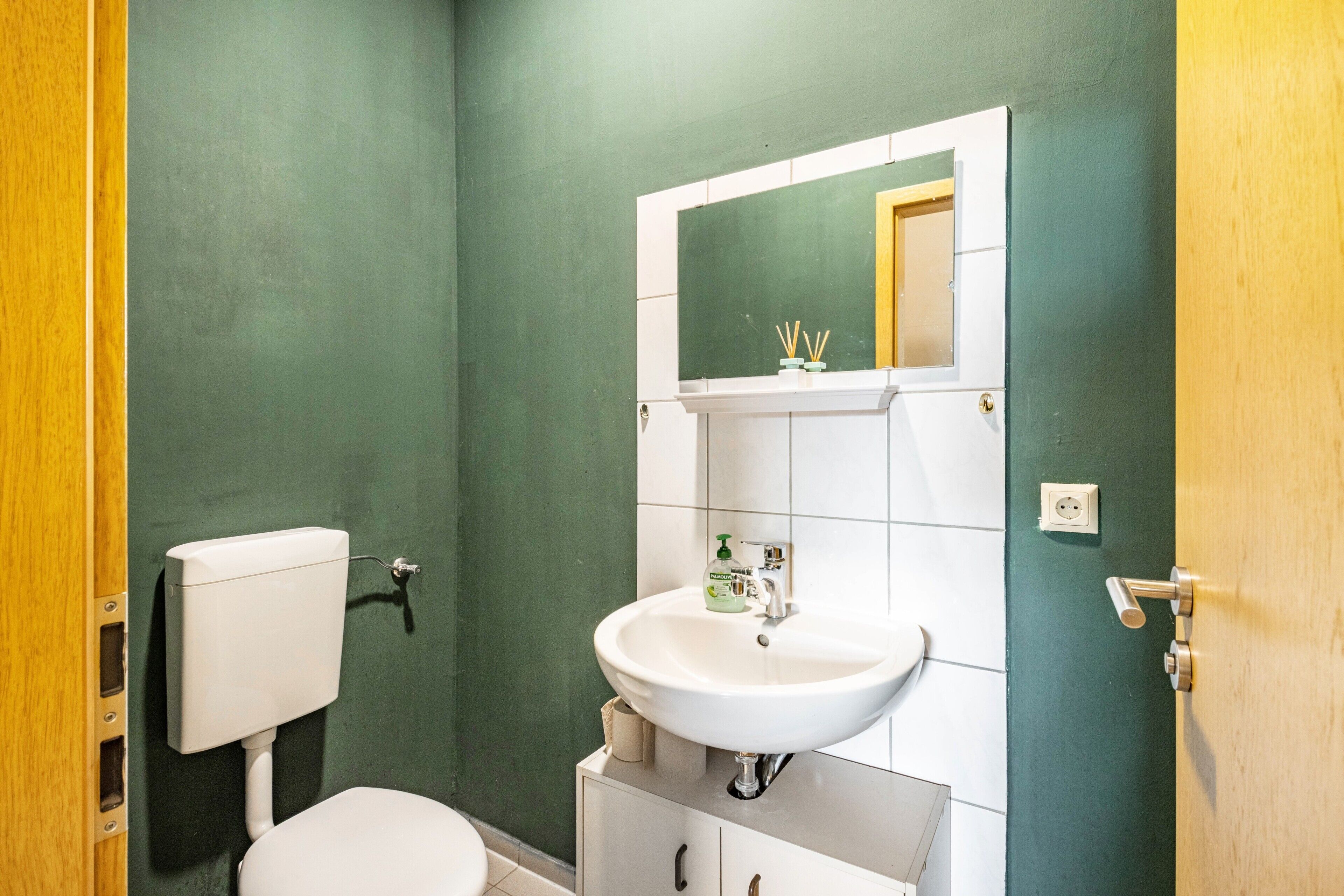 Un bagno con il water, un lavandino e uno specchio.