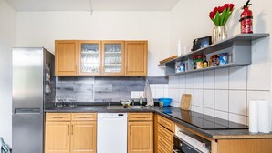 Une cuisine avec des meubles en bois, un réfrigérateur en acier inoxydable, un lave-vaisselle et une cuisinière.