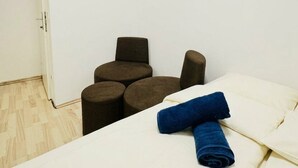 A small, compact room with a bed, a chair, and a small table. - Cozy Room Near FAC Platz | Shared Flat (Vienna)