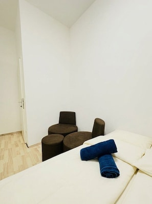 A small, compact room with a bed, a chair, and a small table.