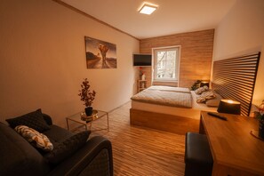 Une chambre à coucher moderne avec un lit, une table de chevet, une lampe et un tableau au mur.