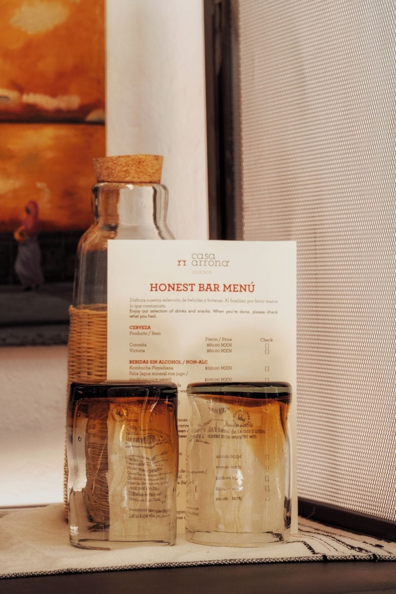 Un menú de bar con una botella corchada y dos vasos de cerveza.