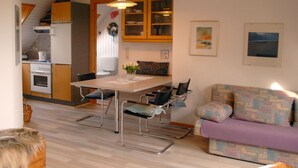 A compact living space with a kitchenette, dining area, and a sofa.