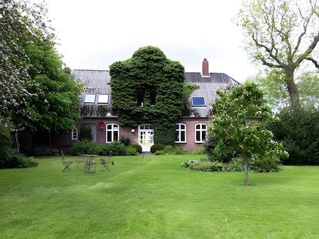 A large, traditional brick house with a symmetrical facade, a central entrance, and a well-maintained lawn.. Hof Neudamm Large Holiday Apartment