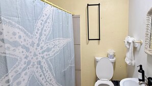 A bathroom with a starfish shower curtain, a toilet, a sink, and a framed mirror on the wall. - Best Location in Vieques! Studio/Steps to Ocean, Biobay, Restaurants and Beaches (Esperanza)