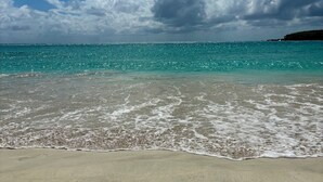 A beach with clear turquoise water, a sandy shore, and a partly cloudy sky. - Best Location in Vieques! Studio/Steps to Ocean, Biobay, Restaurants and Beaches (Esperanza)