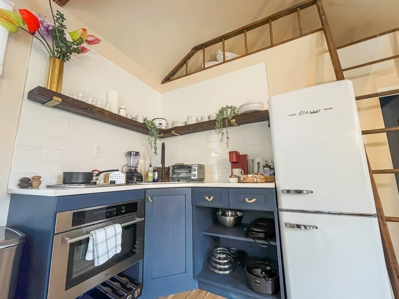 Una cocina compacta con horno empotrado, refrigerador y microondas.