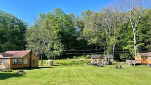 Un quartier résidentiel composé de plusieurs maisons, avec une pelouse bien entretenue et des arbres en arrière-plan.