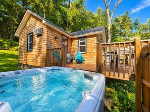 A wooden cabin with a hot tub and a deck. - Catskill Tiny Home, King Bed & Hot Tub on 18 acres (Ellenville)