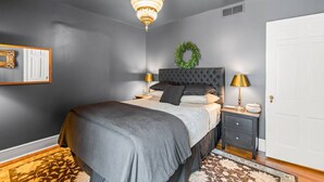 A bedroom with a bed, bedside tables, a chandelier, a door, and a wall-mounted mirror. - 2 Bedroom in Emerywood, High Point, NC (High Point)