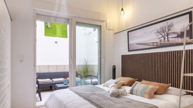 Una camera da letto con un letto, una panca all'esterno e vista su vegetazione.