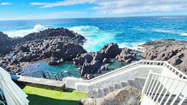 A staircase leading to a rocky coastline with clear blue waters. - House on the seafront (La Matanza de Acentejo)