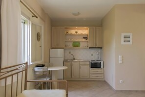 Une cuisine compacte comprenant un coin repas, un four à micro-ondes, un évier et une horloge murale.