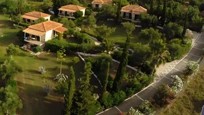 An aerial view of a residential area with multiple houses, each with a tiled roof, surrounded by lush greenery and a well-maintained lawn. - Country House 'No 3 Holiday Home' with Sea View, Wi-Fi, and Air Conditioning (Methoni)