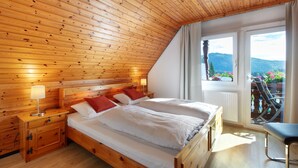 A wooden-paneled room with a bed, bedside tables, and a window with a view.