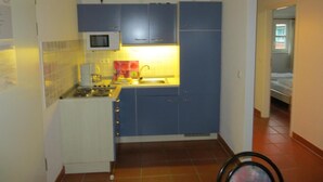 Una cocina compacta con microondas, lavabo y armarios.