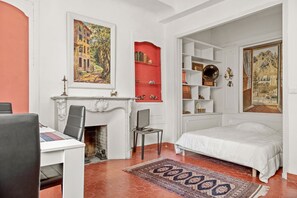 Une chambre à coucher avec une cheminée, un lit, un bureau et une bibliothèque.