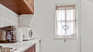 A kitchen with a coffee maker, a toaster, and a window with a heart-shaped curtain. - Apartment '1st Floor' with Wi-Fi (Castellane)